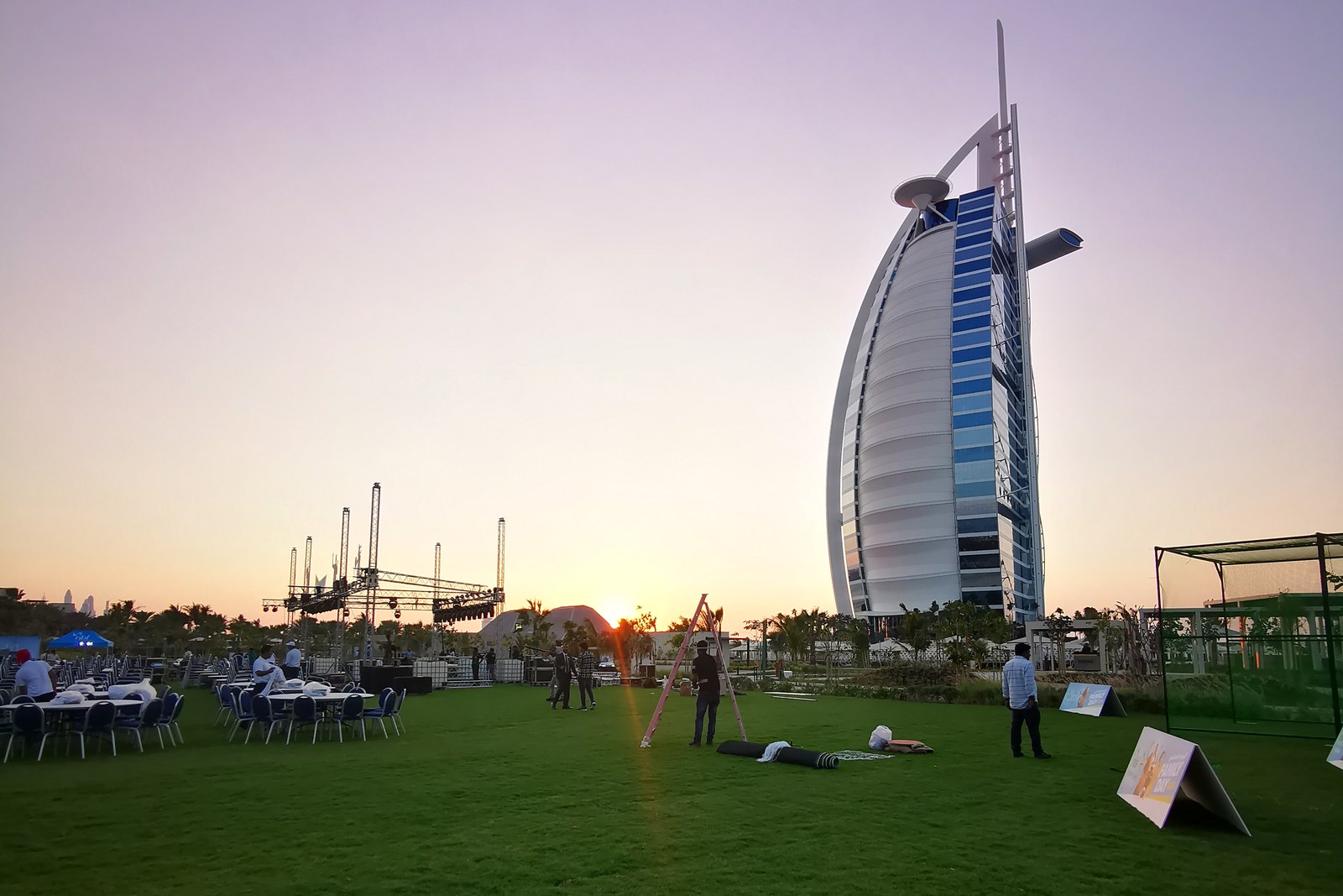 Signage and activity nets being set up on a lawn before an outdoor event