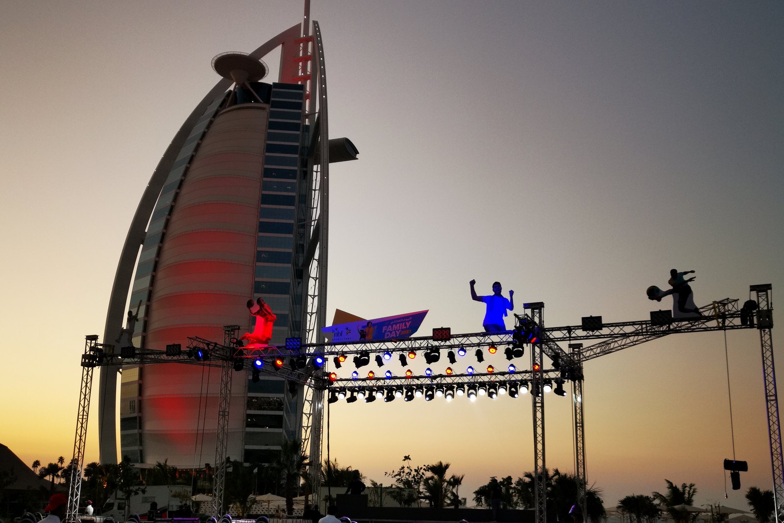 Lighting rig and stage truss lit at dusk with the Burj Al Arab behind