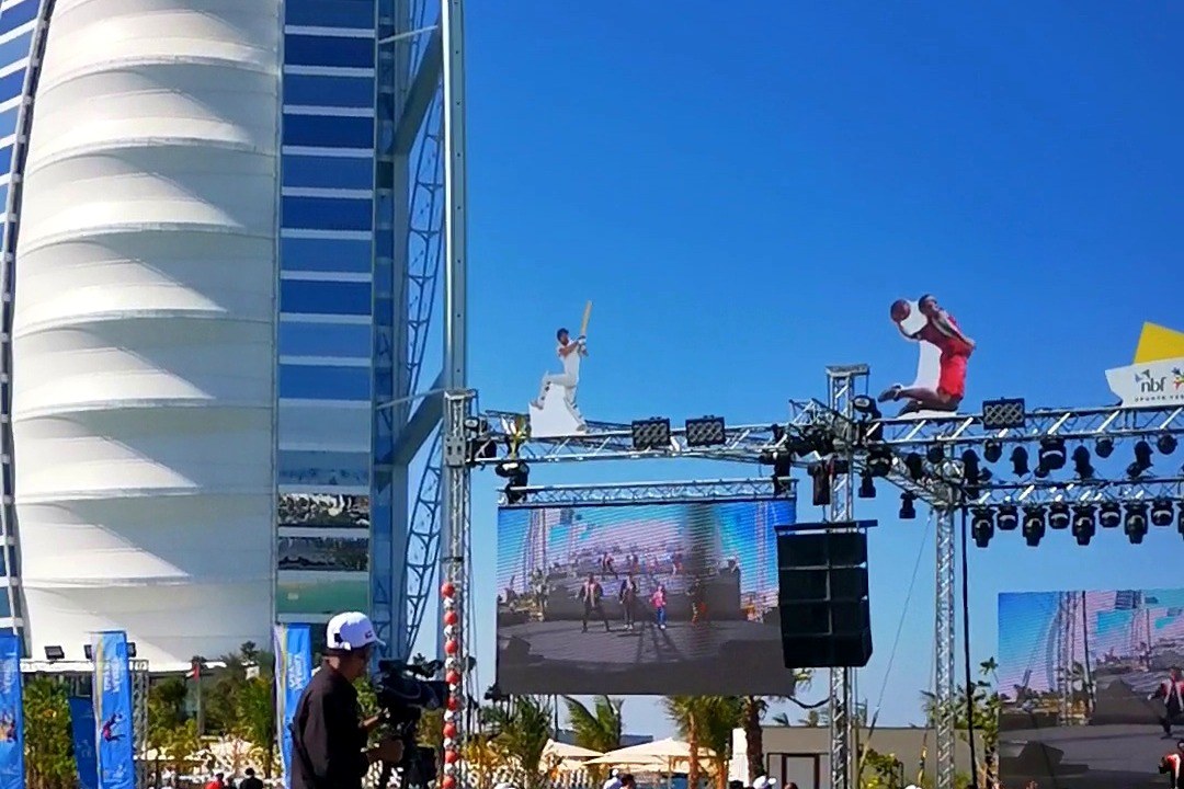 Stage truss, screens and scenic cut-outs against the Burj Al Arab on show day
